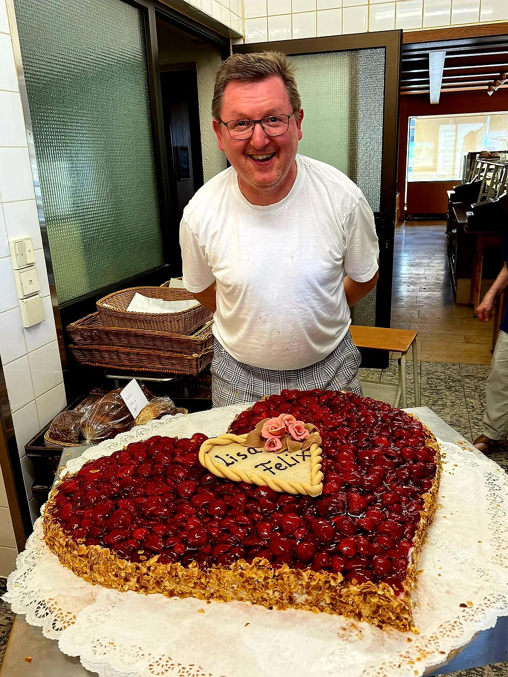 Bäckermeister Schütz mit einer großen Kirsch-Herztorte aus der eigenen Backstube